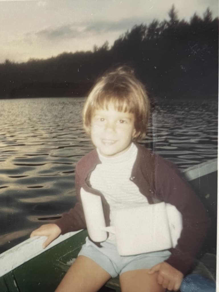 Photo of happy young girl in a boat on a lake