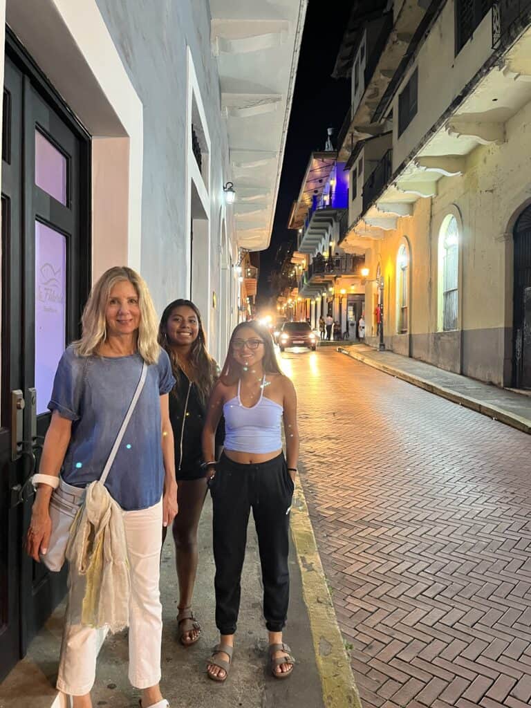 Photo of three people standing on a sidewalk in Panama City's old town.