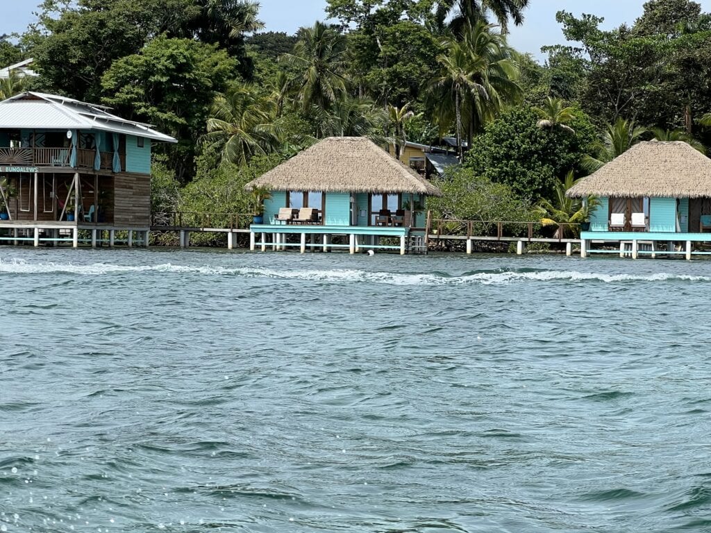 View of two overwater bungalows from the water.