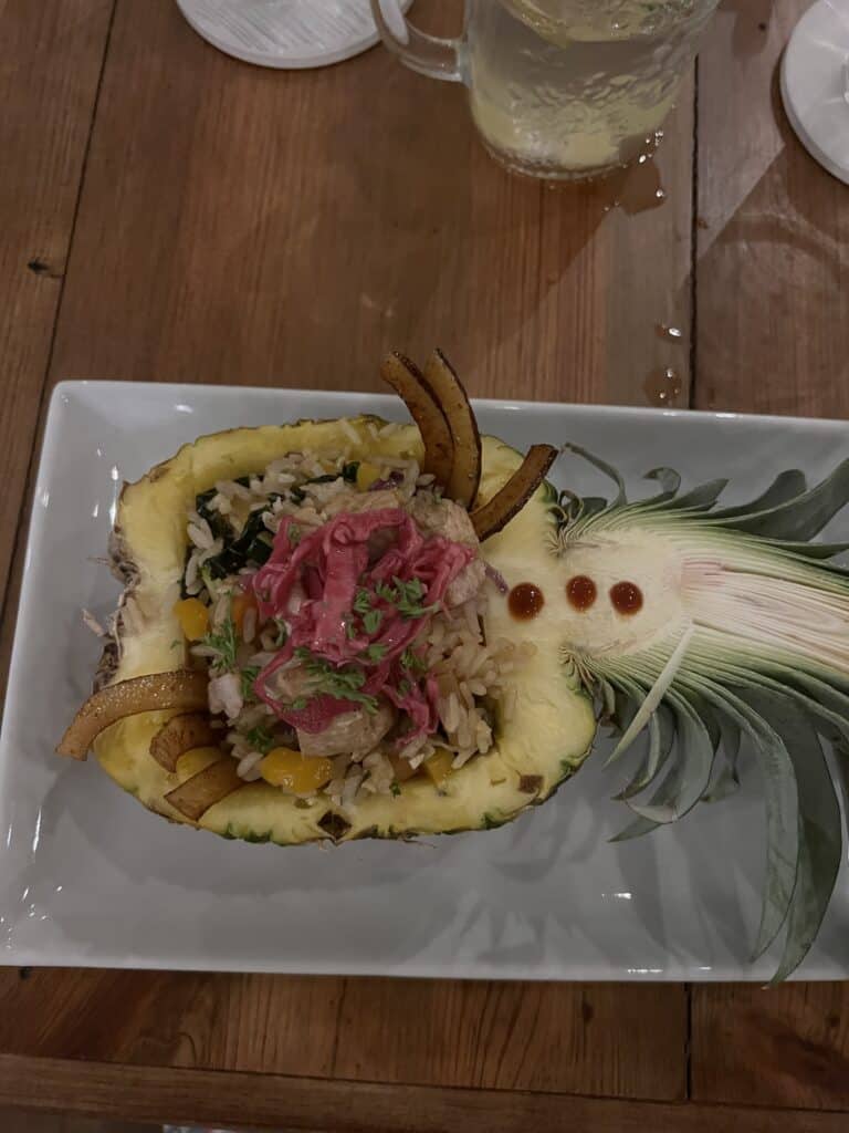 Photo of chicken and rice dish served in a pineapple half. 