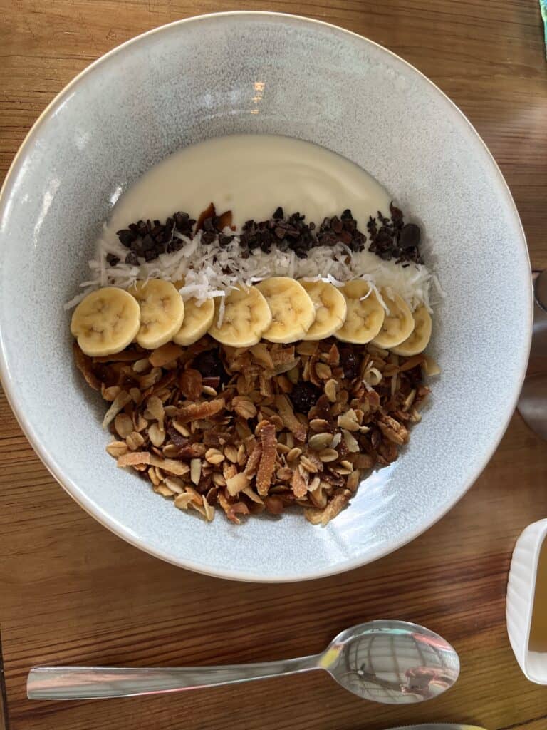 Breakfast is included at our affordable overwater bungalow; pictured is a bowl of homemade yogurt, granola and bananas.