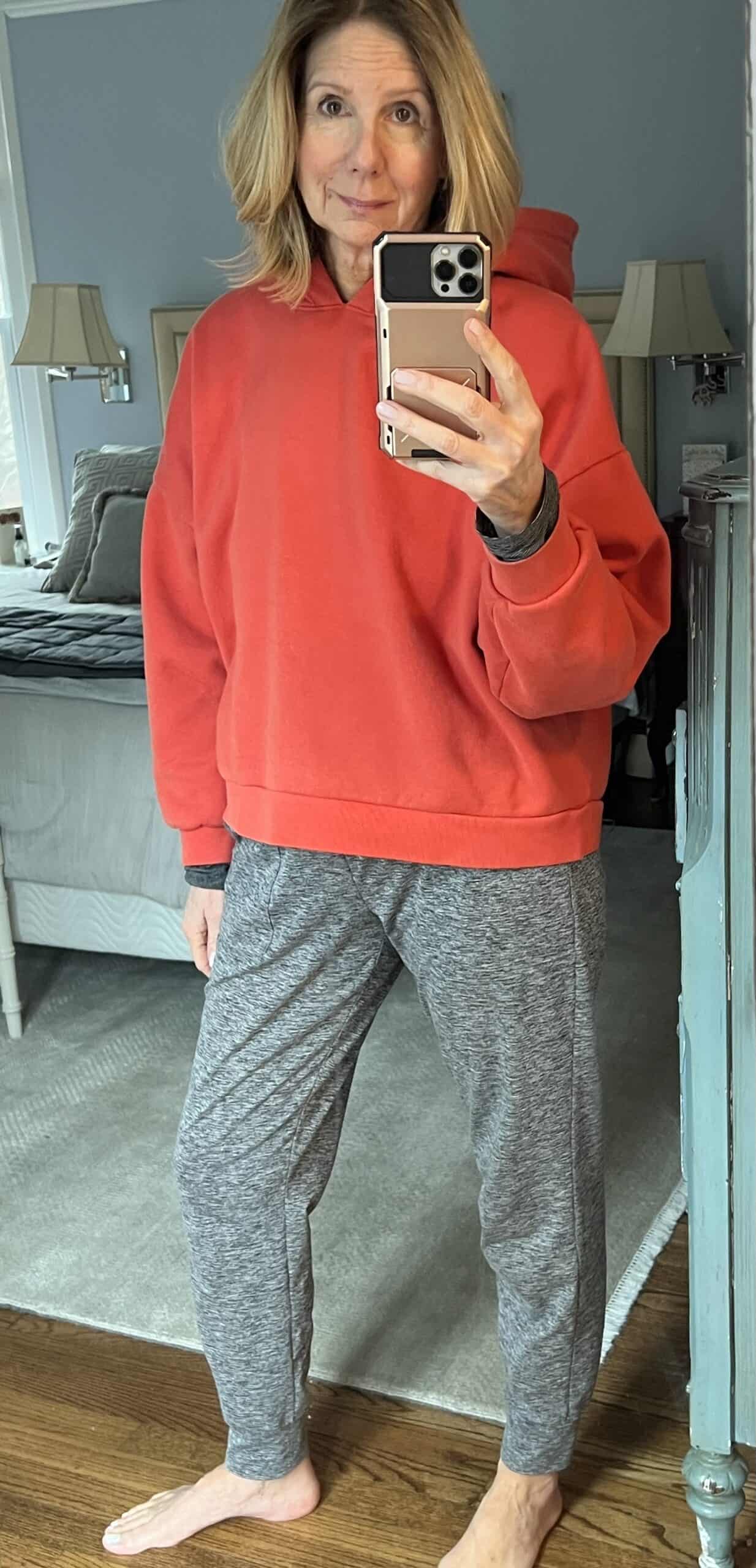 woman in a red hooded sweatshirt and grey sweatpants