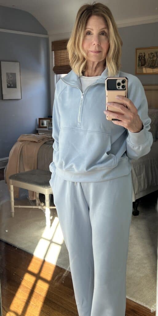 woman in a light blue, matching set showing 1/2 zip collar as she attempts to improve her loungewear game. 