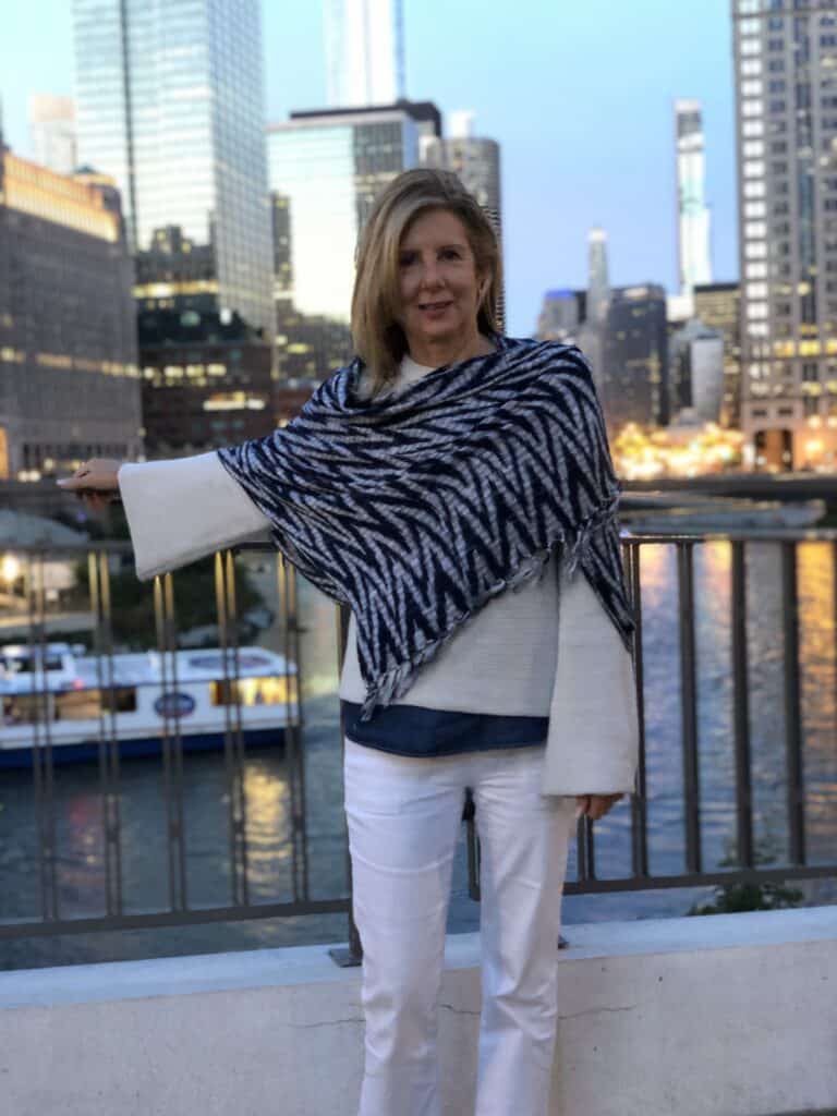 Photo of me against the skyline of Chicago with a bold blue scarf layered over the top. 