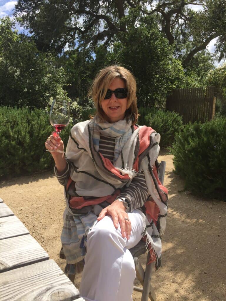 Photo of me at a winery in California wearing a colorful scarf draped across my shoulders.  