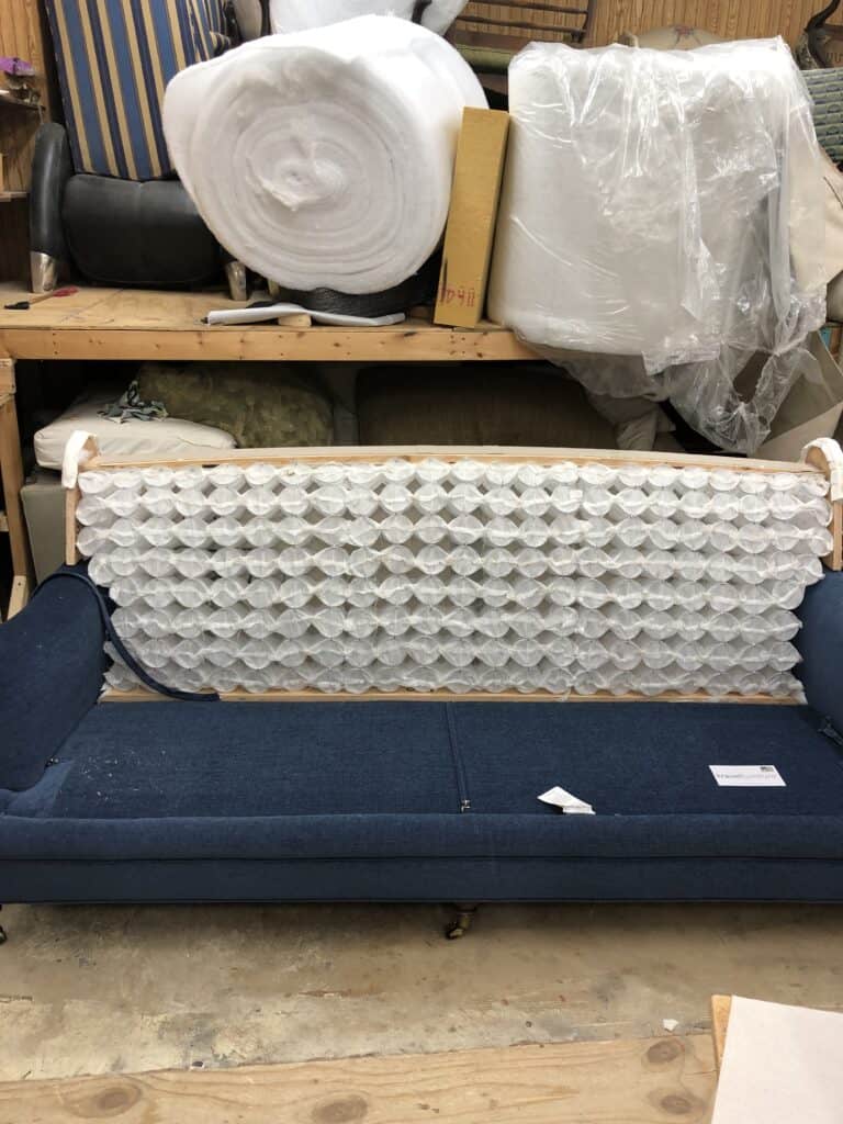 Photo of a sofa opened up to have the roll back modified into a straight back. 
