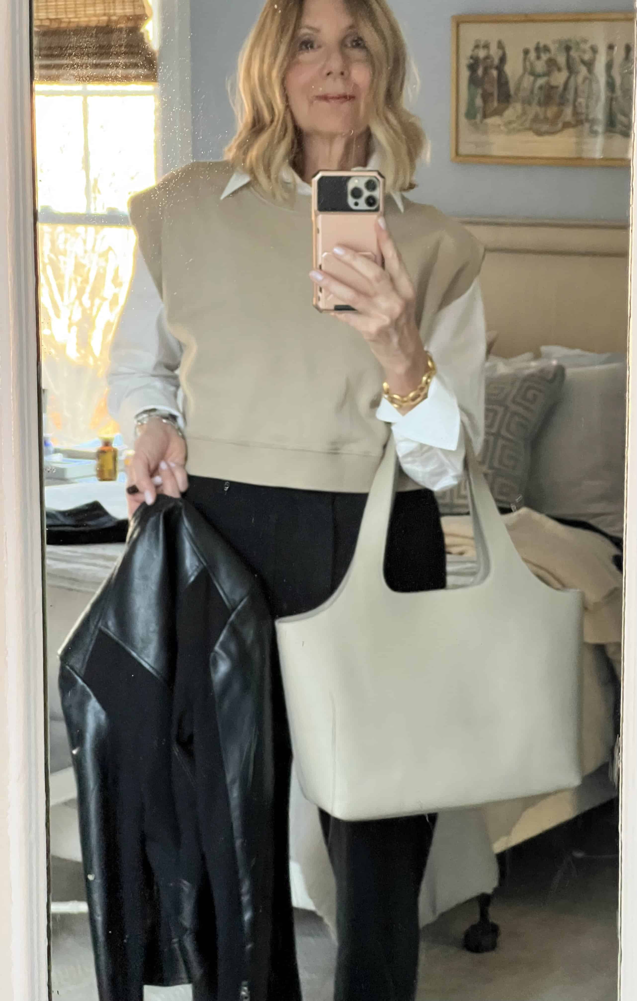Photo of a woman with a Cuyana tote and black leather jacket.