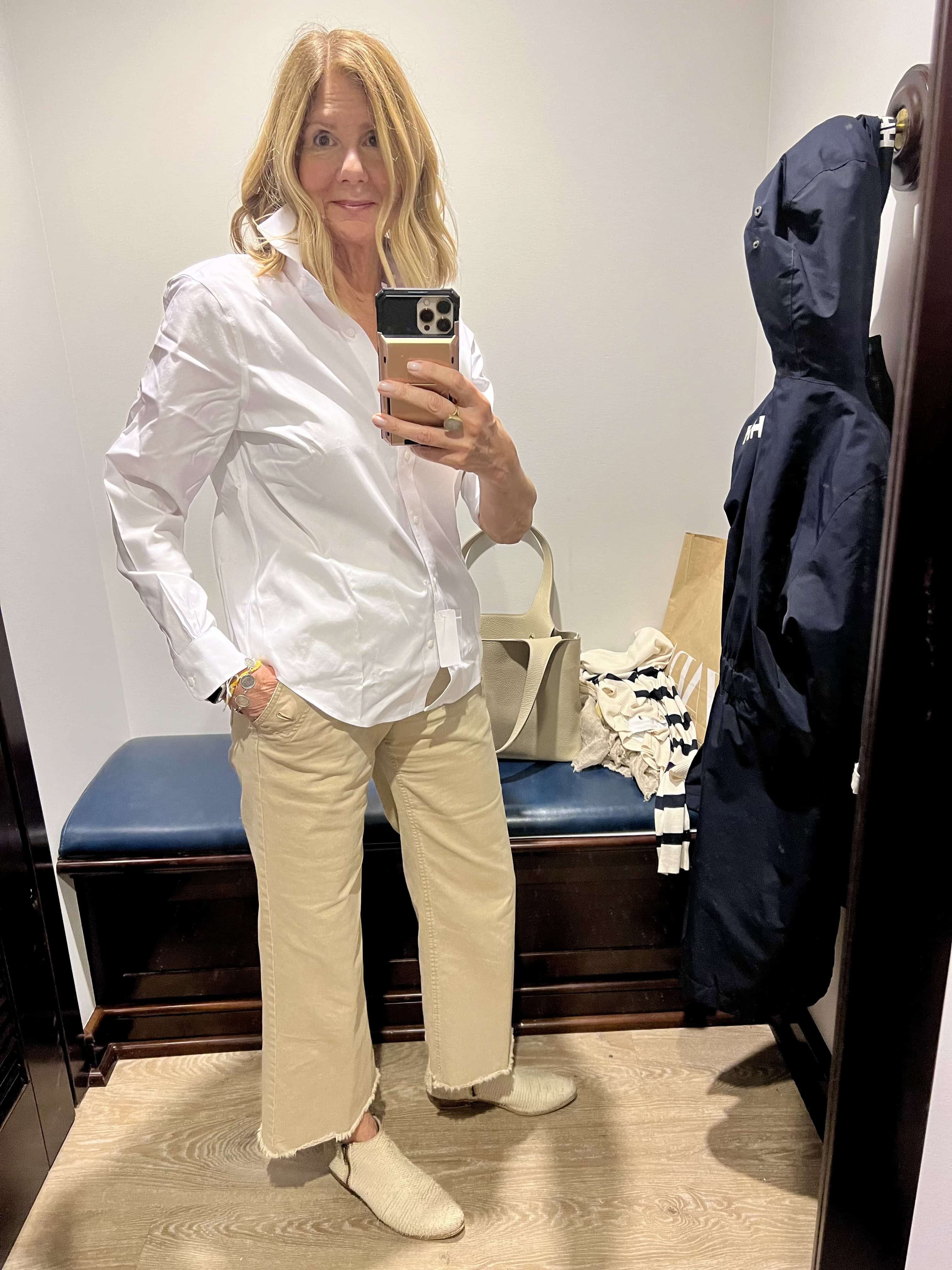 Woman trying on a Brooks Brothers white button down shirt. 