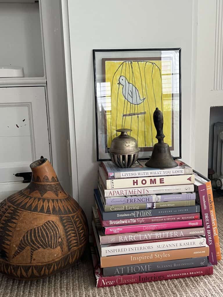 Vignette with stacked home books and a large decorative gourd from Africa. 