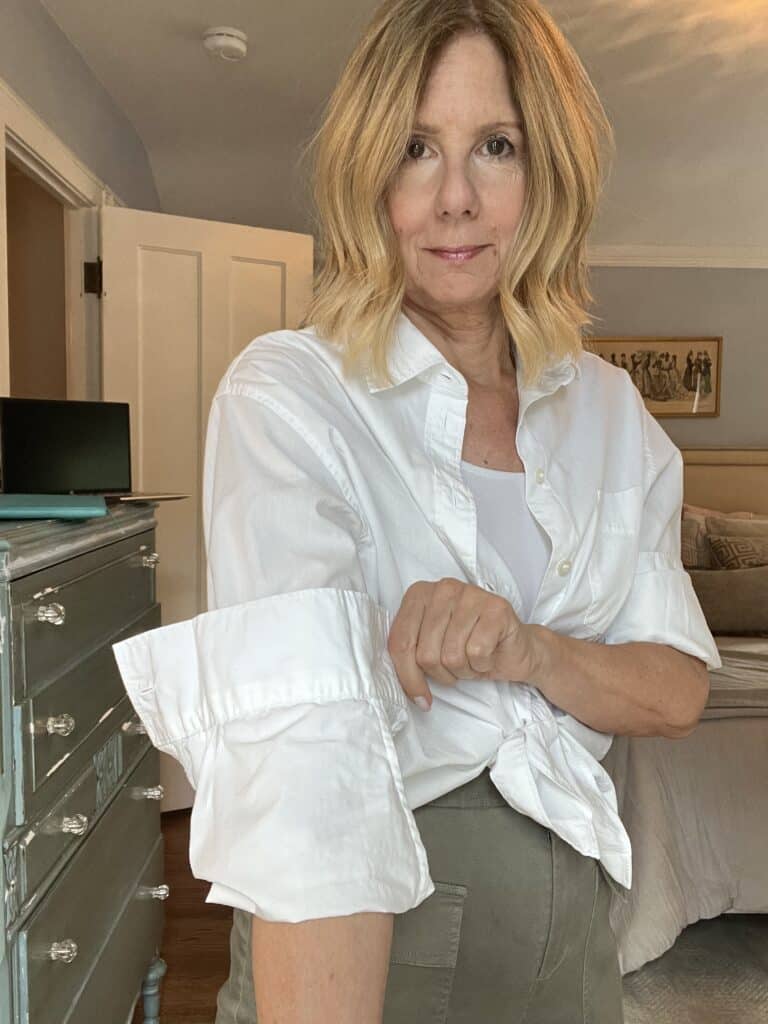 Woman demonstrating how to do an Italin fold on a white shirt. 