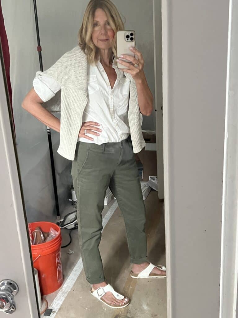 Photo of a woman in green chino's and a white button-down shirt. 