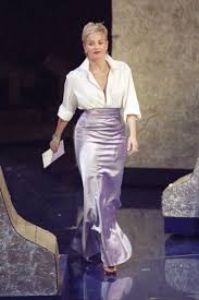 Photo of Sharon Stone in a white button-down shirt and skirt at the 1998 Oscar's. 