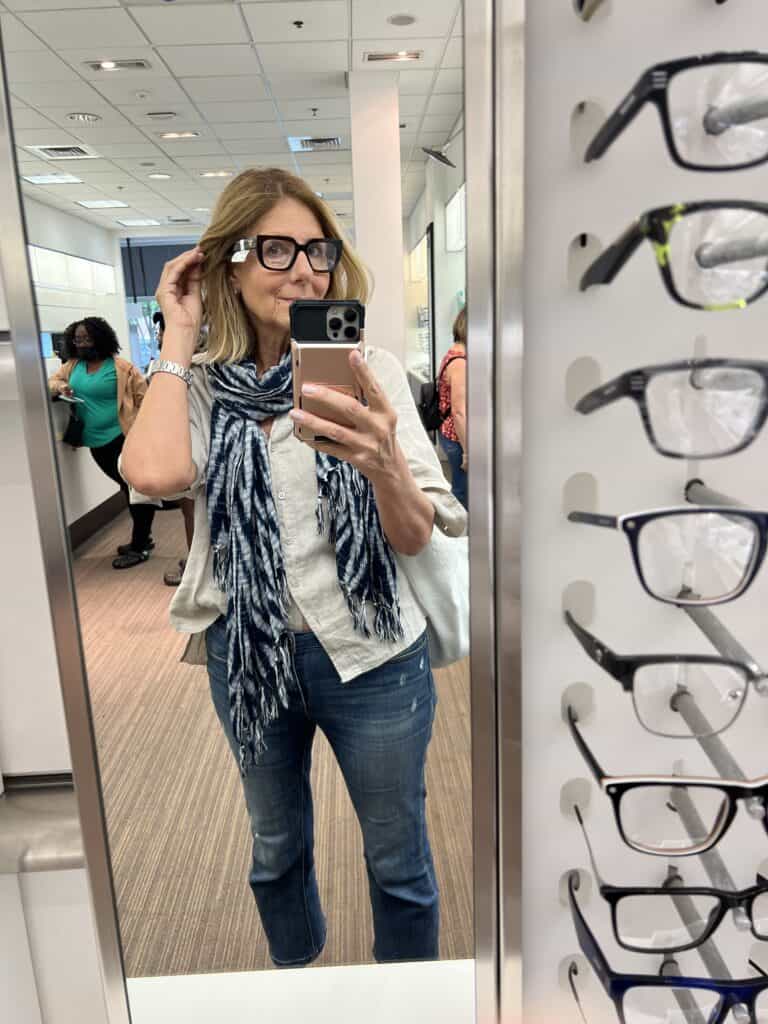 Woman trying on chunky oversized frames by Prada.