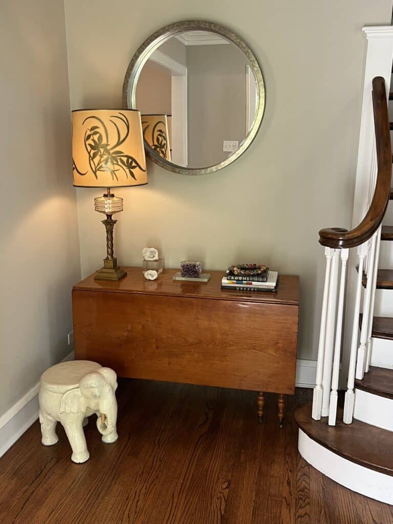 Entryway with an antique table and oversized lamp with hand-painted shade. 