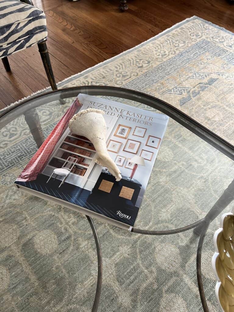 Photo of large sea shell placed on a coffee table book.