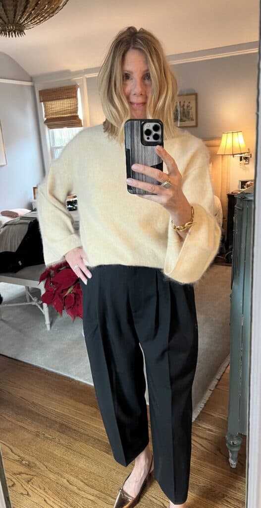 Woman in black pants and the cream brushed cashmere sweater.