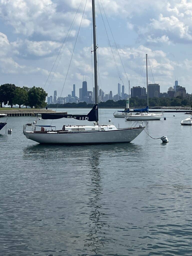 Photo of Chicago's lakefront in summer with sailboats in foreground and Chicago's skyline in the background. 