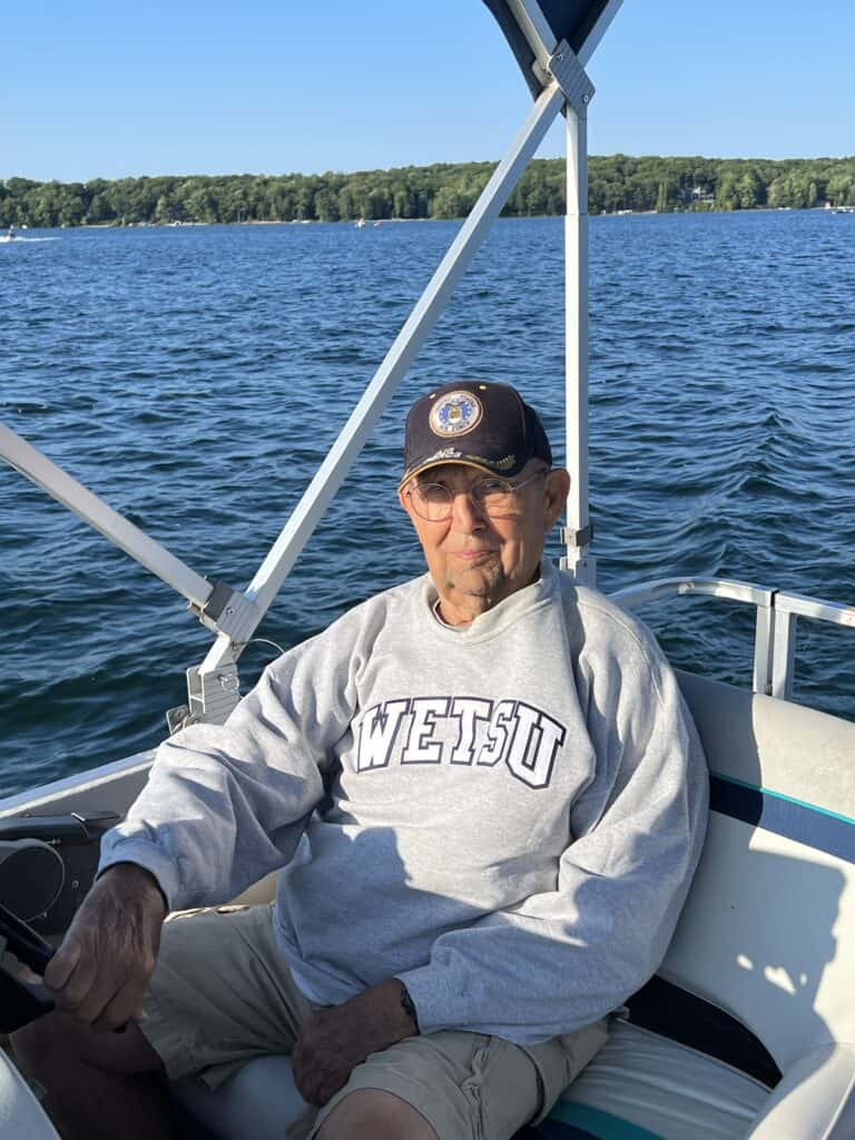 My Dad, driving his pontoon boat in his WETSU sweatshirt. 