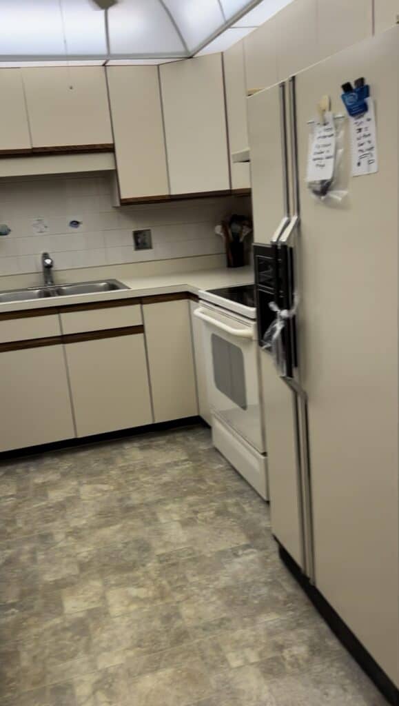 Photo of the right side of the 80's dated kitchen with the almond-colored appliances. 
